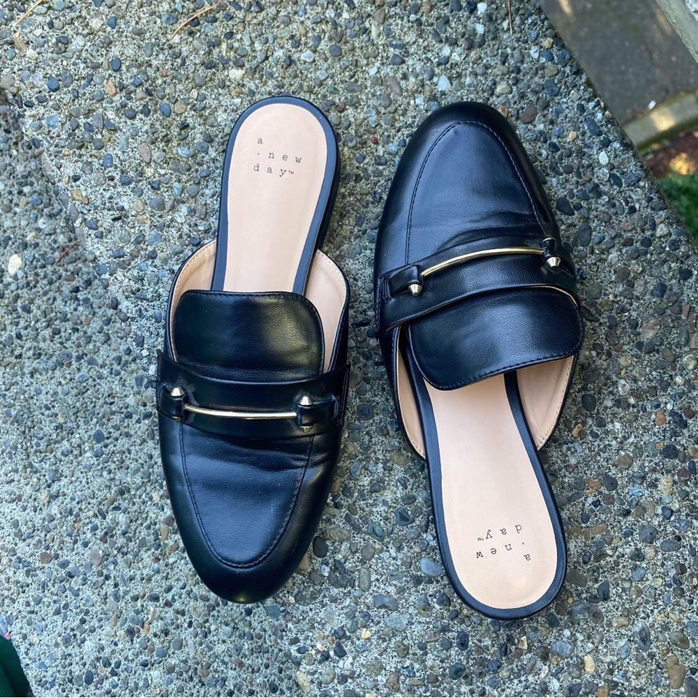 Black loafer flats with gold bar and stud detailing